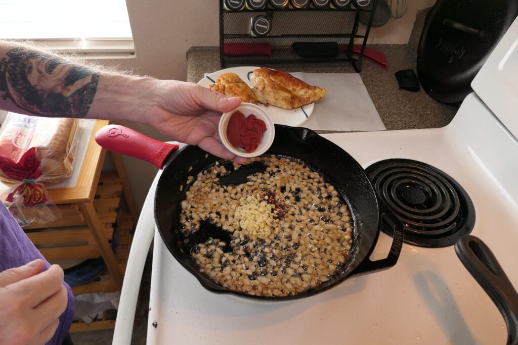 Adding tomato paste to the pan for Marry Me Chicken recipe